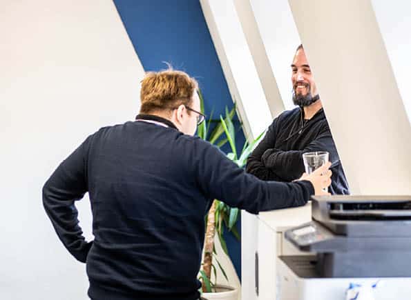 Adam and JC talking in the office