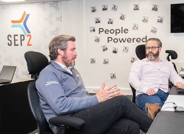 Paul and James talking in the office