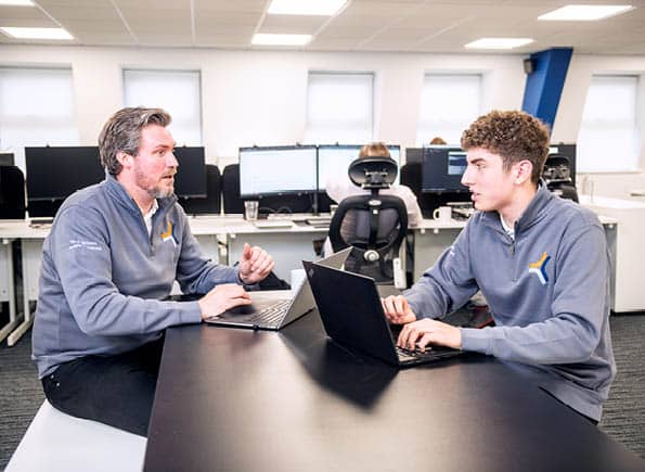 Paul (left) and Alex (right) sat at a table having a discussion