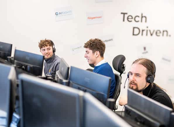 James, Alex and JC working at their computers with the Tech Driven wall in the background