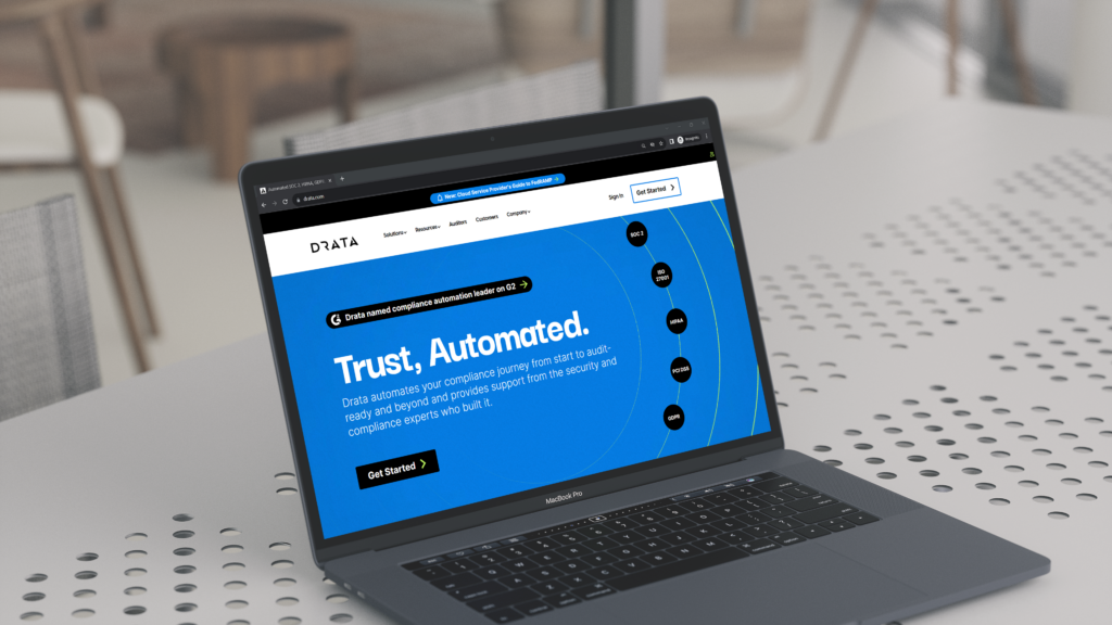 Drata website homepage shown on a macbook